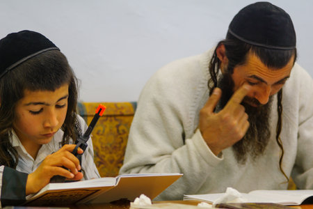 SAFED, ISRAEL - MAR 11, 2017: Traditional Purim (Jewish Holiday) in the old Abuhav synagogue with prayers, some in costumes, attend a reading of the megillah (Scroll of Esther). Safed (Tzfat), Israelのeditorial素材