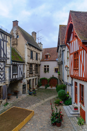 Sunrise view of a square (place de la petite etape aux vins), with half-timbered houses, in the medieval village Noyers-sur-Serein, Burgundy, Franceの写真素材