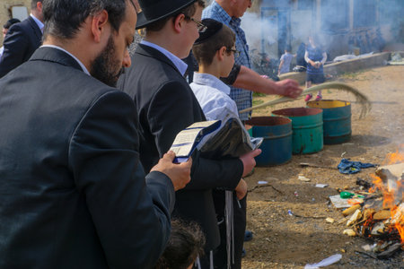 HAIFA, ISRAEL - APRIL 10, 2017: Jewish people perform Biur (burning) Chametz (leavened foods), and say blessing, in Haifa, Israel. This is part of the Passover holiday traditionsのeditorial素材