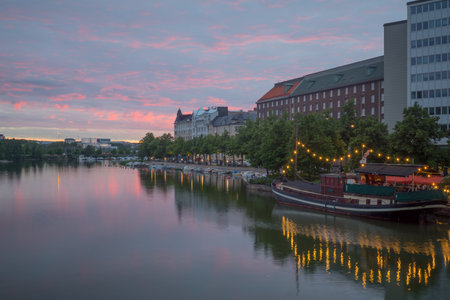 HELSINKI, FINLAND - JUNE 23, 2017: Sunset view of kaisaniemenlahti bay, with local businesses, locals and visitors, in Helsinki, Finlandのeditorial素材