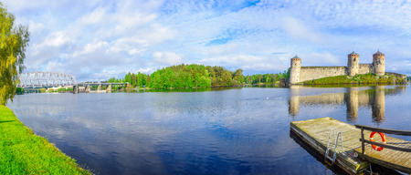 Panoramic view of a train bridge and the Olavinlinna castle in Savonlinna, Finland. It is a 15th-century three-tower castleの写真素材
