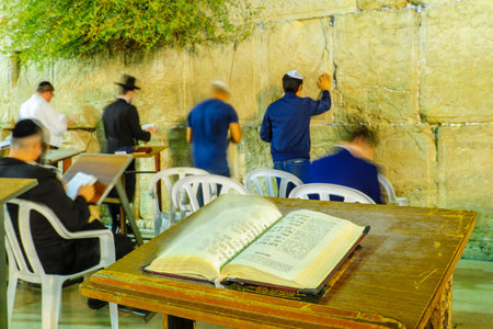 JERUSALEM, ISRAEL - SEPTEMBER 06, 2017:  Night scene of the Western Wall with the book of Psalm, Tehilim, and Jewish prayers, in Jerusalem, Israel. This is the holiest place in Jewish traditionのeditorial素材