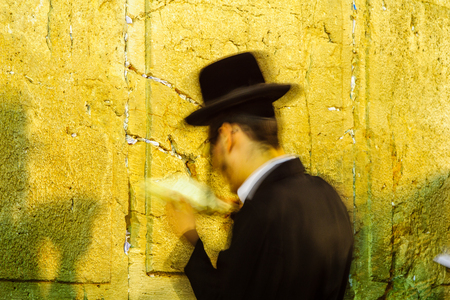 Long exposure of a Jewish prayer at the Western Wall, at night. Jerusalem, Israel. This is the holiest place in Jewish traditionの写真素材