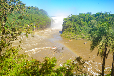 The waterfalls, rainbow and tourist boats in the Iguazu National Park, on the border of Argentina and Brazil. Argentinian sideの写真素材