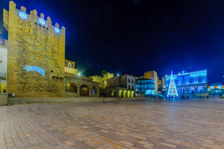 CACERES, SPAIN - DECEMBER 21, 2017: Night scene of the Plaza Mayor (main square), with various Christmas decorations, local businesses, locals and visitors, in Caceres, Extremadura, Spainのeditorial素材