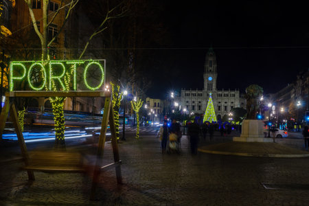 PORTO, PORTUGAL - DECEMBER 24, 2017: Night scene of the Avenida dos Aliados, and the city hall, with a Christmas tree, locals and visitors, in Porto, Portugalのeditorial素材