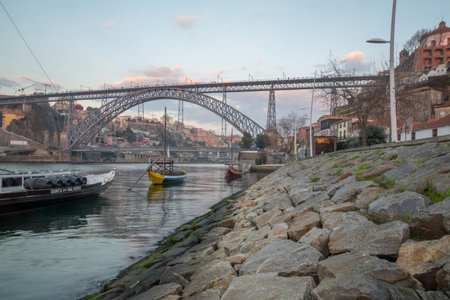 PORTO, PORTUGAL - DECEMBER 24, 2017: Sunset view of the Douro river, Dom Luis I Bridge and the Ribeira (riverside), with various boats, locals and visitors, in Porto, Portugalのeditorial素材