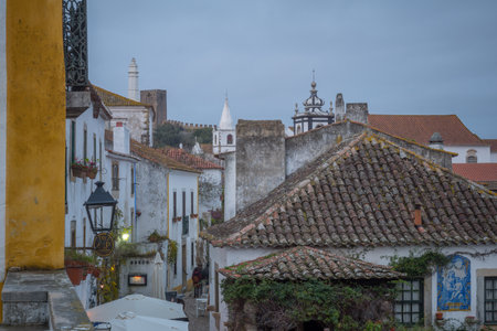 OBIDOS, PORTUGAL - DECEMBER 27, 2017: View of an alley in the old town, with local businesses, locals and visitors, in Obidos, Portugalのeditorial素材