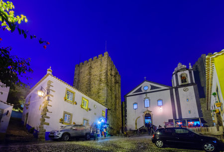 OBIDOS, PORTUGAL - DECEMBER 27, 2017: View of the old town, with local businesses, Saint James church, Christmas decorations, locals and visitors, in Obidos, Portugalのeditorial素材