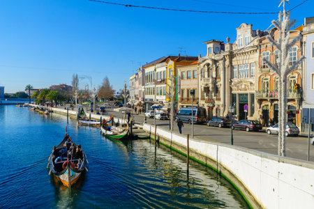 AVEIRO, PORTUGAL - DECEMBER 23, 2017: View of canals, boats, old buildings, local businesses, locals and visitors, in Aveiro, Portugalのeditorial素材