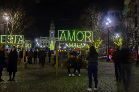 PORTO, PORTUGAL - DECEMBER 24, 2017: Night scene of the Avenida dos Aliados, and the city hall, with multilingual messages, a Christmas tree, locals and visitors, in Porto, Portugalのeditorial素材