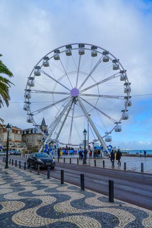 CASCAIS, PORTUGAL - DECEMBER 28, 2017: View of the Ribeira Beach, the Seixas Palace and the Ferris Wheel, with visitors, in Cascais, Portugalのeditorial素材
