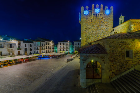 CACERES, SPAIN - DECEMBER 21, 2017: Night scene of the Plaza Mayor (main square), with various Christmas decorations, local businesses, locals and visitors, in Caceres, Extremadura, Spainのeditorial素材