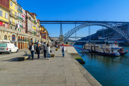 PORTO, PORTUGAL - DECEMBER 24, 2017: View of the Dom Luis I Bridge, the Douro river and the Ribeira (riverside), with colorful buildings, locals and visitors, in Porto, Portugalのeditorial素材
