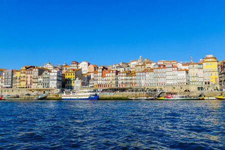 PORTO, PORTUGAL - DECEMBER 24, 2017: View of the Douro river and the Ribeira (riverside), with colorful buildings, locals and visitors, in Porto, Portugalのeditorial素材
