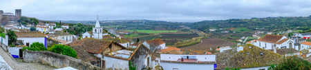 Panoramic view of the old town, with rooftops, and nearby countryside, in Obidos, Portugalの写真素材