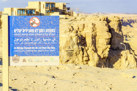 Mitzpe Ramon, Israel - January 18, 2019: Dusty sign calling not to feed the ibex, and landscape of Makhtesh (crater) Ramon, in the Negev Desert, Southern Israelのeditorial素材