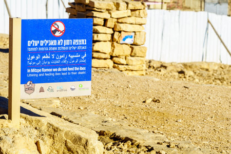 Mitzpe Ramon, Israel - January 19, 2019: Dusty sign calling not to feed the ibex, and landscape of Makhtesh (crater) Ramon, in the Negev Desert, Southern Israelのeditorial素材