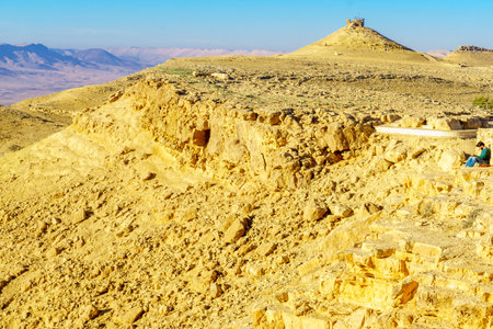 Mitzpe Ramon, Israel - January 19, 2019: View of Makhtesh (crater) Ramon with Camel Mount lookout and a visitor, in the Negev Desert, Southern Israelのeditorial素材