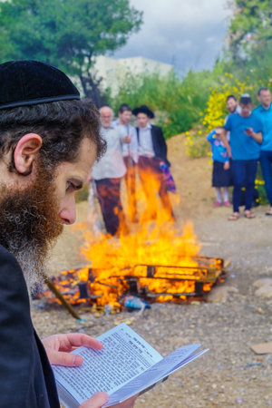 Haifa, Israel - April 19, 2019: Jewish man read a blessing, part of a Biur (burning) Chametz (leavened foods) ceremony, in Haifa, Israel. This is part of the Passover holiday traditionsのeditorial素材