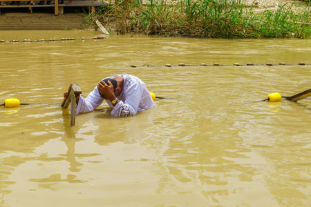 Qasr el Yahud, West Bank - April 24, 2019: Pilgrims baptize in Qasr el Yahud (Castle of the Jews), in the Jordan River. It is the traditional site of the baptism of Jesus by John the Baptistのeditorial素材