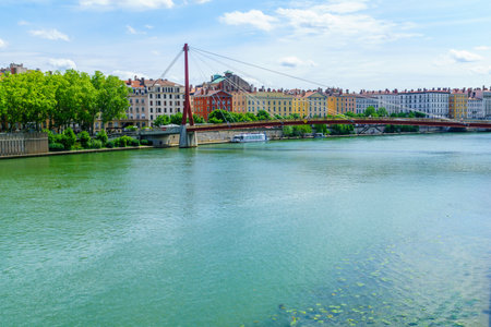 Lyon, France - May 10, 2019: The Saone River, colorful houses, with locals and visitors, in Lyon,...