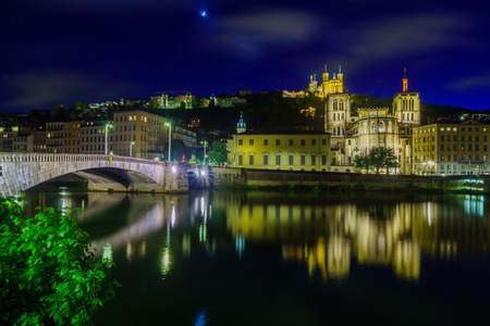 Night view of the Saone river, Bonaparte bridge, the Saint-Jean cathedral, and Notre-Dame basilica, in Lyon, Franceの写真素材