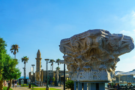 Caesarea, Israel - July 22, 2019: View of a Roma era column capital, and the Bosnian mosque, with visitors, in Caesarea National Park, Northern Israelのeditorial素材