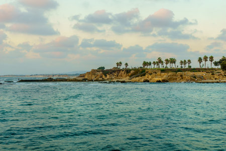 Caesarea, Israel - July 22, 2019: Sunset view of the old port, with fishermen and other visitors, in Caesarea National Park, Northern Israelのeditorial素材