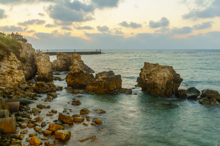 Caesarea, Israel - July 22, 2019: Sunset view of the old port, with fishermen and other visitors, in Caesarea National Park, Northern Israelのeditorial素材