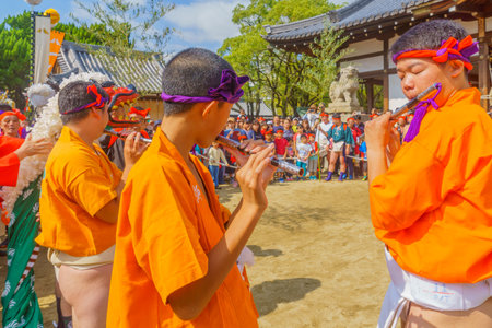 Himeji, Japan - October 14, 2019: Men in traditional dressing play flute, and crowd. Part of the Nada no Kenka Festival, in Himeji, Japanのeditorial素材