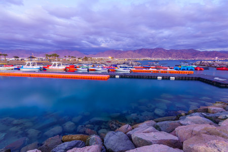 Eilat, Israel - January 17, 2020: Evening scene of the new marina and hotels, with locals and visitors and Aqaba (Jordan) in the background, in Eilat, southernmost city in Israelのeditorial素材