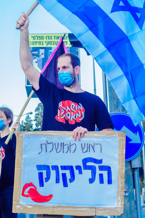 Haifa, Israel - October 17, 2020: People with flags and signs are taking part in the Black Flags protest against the government, Bibi Netanyahu, and the recent lock-down in Ziv center, Haifa, Israelのeditorial素材