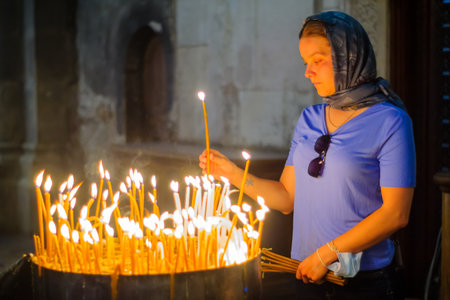 Jerusalem, Israel - April 30, 2021: View of a pilgrim lighting a candle, on Orthodox Good Friday, in...
