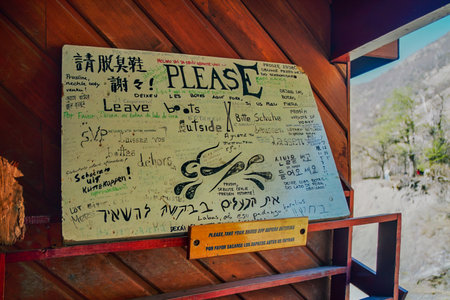 Torres del Paine, Chile - October 03, 2005: Multilingual sign in a trail cabin - Please leave the boots outside. Torres del Paineのeditorial素材