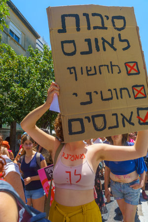 Haifa, Israel - July 09, 2021: Slut walk protest, against the rape culture: people with signs marching in the street - message - reason for rape is only rapist. Haifa, Israelのeditorial素材