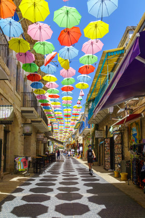Jerusalem, Israel - August 30, 2021: Pedestrians and colorful umbrellas (parasols), in Yoel Moshe Solomon Street, the historic Nachalat Shiva neighborhood, the picturesque center of Jerusalem, Israelのeditorial素材