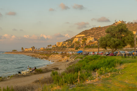 Haifa, Israel - September 07, 2021: Sunset view of the Carmel Coast, the Mediterranean Sea, the promenade, and Mount Carmel slopes, with visitors, in Haifa, Israelのeditorial素材