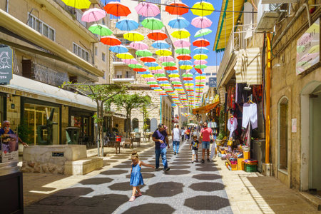 Jerusalem, Israel - August 30, 2021: Pedestrians and colorful umbrellas (parasols), in Yoel Moshe Solomon Street, the historic Nachalat Shiva neighborhood, the picturesque center of Jerusalem, Israelのeditorial素材