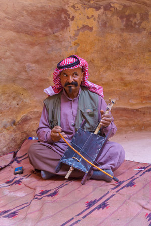 Petra, Jordan - October 23, 2021: Portrait of a local Bedouin man plays a Rebab, in the ancient Nabatean city of Petra, Southern Jordanのeditorial素材