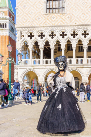 Venice, Italy - March 01, 2022: Woman dressed in traditional costume, in St. Marks Square, part of the Venice Mask Carnival, Veneto, Italyのeditorial素材