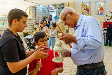 Nazareth, Israel - April 23, 2022: Believers are sharing the Holy Fire, part of Orthodox Easter Holy...