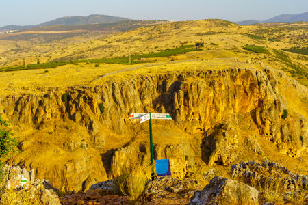 Arbel, Israel - May 21, 2022: View of directional signs, landscape, and the cliffs of Mount Nitai in...