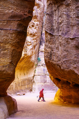 Petra, Jordan - October 23, 2021: View of the Siq canyon, that leads to the ancient Nabatean city of Petra, with a local worker, in Southern Jordanのeditorial素材