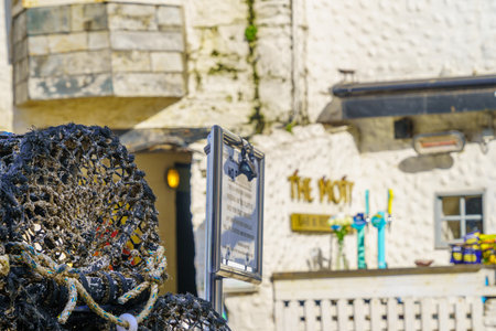 Port Isaac, UK - October 15, 2022: View of lobster traps and local bar, in Port Isaac, Cornwall, England, UKのeditorial素材
