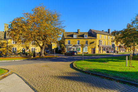 Broadway, UK - October 18, 2022: Street view with local businesses, locals, and visitors, in...