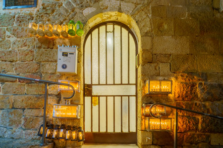Jerusalem, Israel - December 24, 2022: Alley in the Jewish quarter of the Old City, with various Traditional Menorahs (Hanukkah Lamps) with olive oil candles, placed near the doors. Jerusalem, Israelのeditorial素材