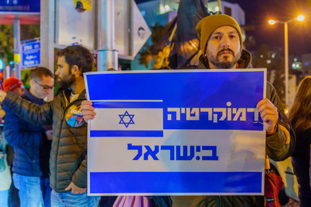 Haifa, Israel - January 14, 2023: People protest with signs against the legislative plans of the new government, in Haifa, Israelのeditorial素材