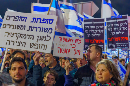 Haifa, Israel - March 18, 2023: Protesters with various signs and flags attend a demonstration against the plans of the new government, claiming its anti-democratic, in Haifa, Israelのeditorial素材