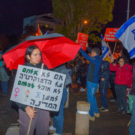Haifa, Israel - March 18, 2023: Protesters with various signs and flags attend a demonstration against the plans of the new government, claiming its anti-democratic, in Haifa, Israelのeditorial素材